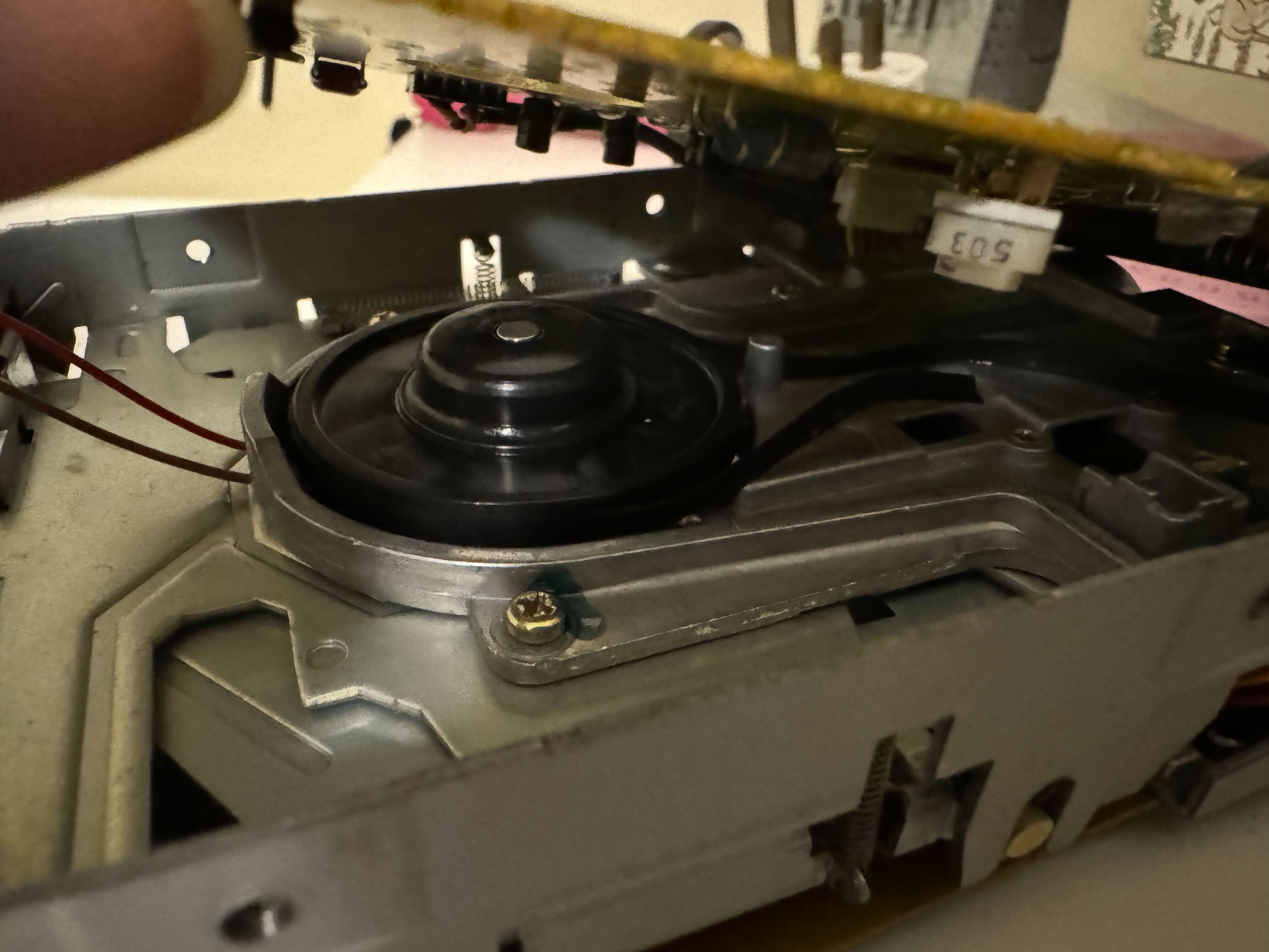 An open disk drive showing two spools with a perished rubber band around them.